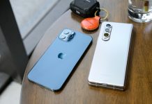 two cell phones sitting on top of a wooden table