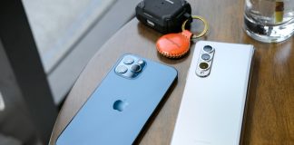 two cell phones sitting on top of a wooden table