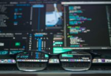 Eyeglasses reflecting computer code on a monitor, ideal for technology and programming themes.