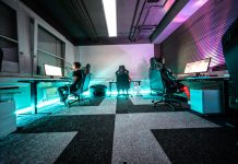 A group of people sitting around a computer desk