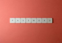 Focus on password security with white keyboard tiles spelling 'PASSWORD' on a coral background.
