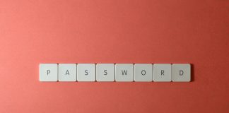 Focus on password security with white keyboard tiles spelling 'PASSWORD' on a coral background.